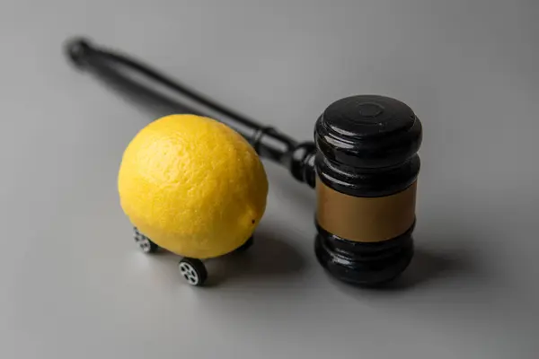 Tekerlekli bir limon ve yargıç tokmağı. Limon hukuku kavramı.