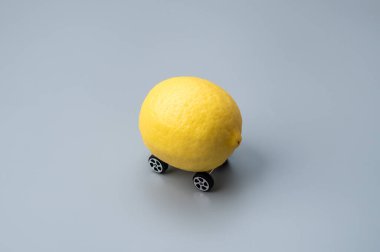 Üzerinde küçük tekerlekler olan bir limon. Limonlu araba, arıza veya arıza araba konsepti.