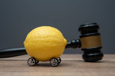 Tekerlekli bir limon ve yargıç tokmağı. Limon hukuku kavramı.