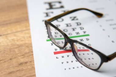 Göz çizelgesi olan bir gözlük. Görüş ve göz bakımı kavramı.