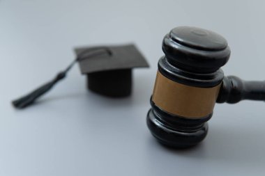 Siyah tokmak ve siyah mezuniyet şapkası. Eğitim hukuku kavramı.