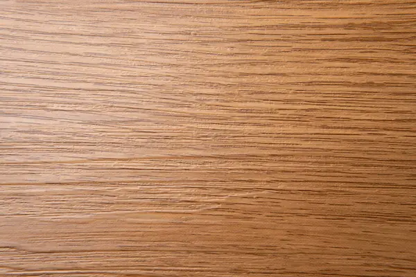 Açık kahverengi ahşap bir yüzeyin yukarıdan aşağı görüntüsü, yatay çizgilerle doğal tahıl desenlerini ve ton çeşitliliklerini gözler önüne seriyor..