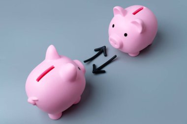 İki domuz kumbarası ve oklar bir değiş tokuşu ya da transferi simgeliyor. Bir fon konsepti dahilinde mal değişimi veya ticareti.