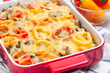 Patatesli güveç, sosis ve renkli dolma biber, fırın kabında, yatay, yakın plan.