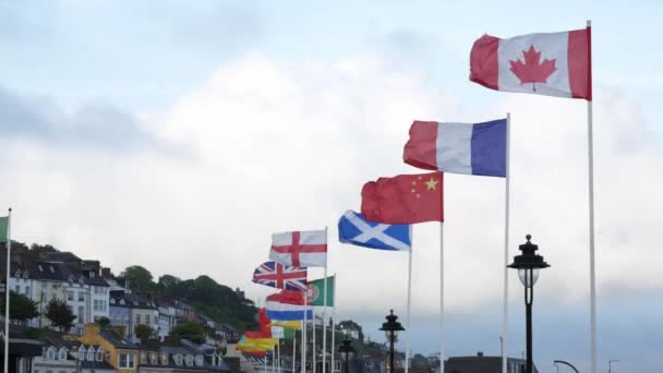 2022年8月23日アイルランドのコブにあるケネディパークでは 青い空の背景に風になびくさまざまな国の国旗 — ストック動画
