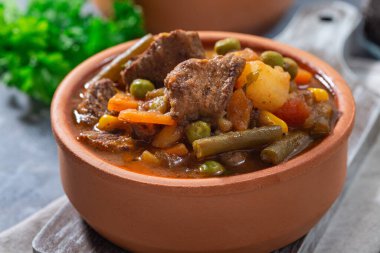 Patatesli biftek güveci, yeşil fasulye, havuç, kereviz, bezelye ve mısır, seramik kasede, yatay, yakın plan