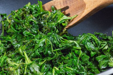 Sarımsak ve balzamik sirkeyle karıştırılmış zeytinyağında pişirilmiş Arugula ya da roket salatası. Kızartma tavasında bir meze hazırlıyorum, yatay olarak.