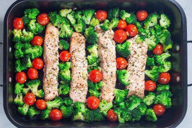 Fırında somon filetosu brokoli ve domates kızartma tepsisinde, yatay, üst manzara