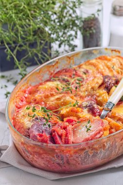 Fırında pişmiş tatlı patates, havuç ve pancar kökü graten üzerine erimiş peynir ve taze kekik, dikey