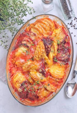 Tatlı patates, havuç ve pancar kökü graten, taze kekik ile baharatlı ve eritilmiş peynirle kaplı, dikey üst görünüm