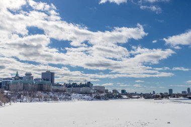 Having a walk through the Majors Hill Park in downtown Ottawa Canada with view to the historical buildings of the Canadian parliament and its surroundings at a cold but sunny day in winter.