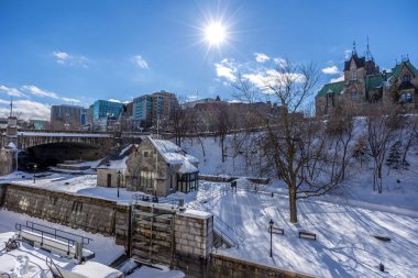 Having a walk through the Majors Hill Park in downtown Ottawa Canada with view to the historical buildings of the Canadian parliament and its surroundings at a cold but sunny day in winter.