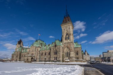 Having a walk on the Parliament Hill in downtown Ottawa Canada with view to the historical buildings of the Canadian parliament and its surroundings at a cold but sunny day in winter.