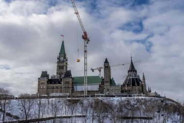 Having a walk through the Majors Hill Park in downtown Ottawa Canada with view to the historical buildings of the Canadian parliament and its surroundings at a cold but sunny day in winter.