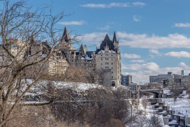 Having a walk through the Majors Hill Park in downtown Ottawa Canada with view to the historical buildings of the Canadian parliament and its surroundings at a cold but sunny day in winter.