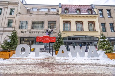 Ottawa, Canada - February 08th 2023: A german photographer discovering the pedestrian zone in downtown Ottawa, viewing the Ottawa sign at the so called winter lude. clipart