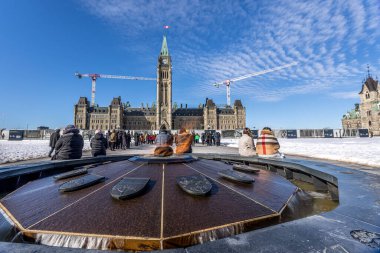 Ottawa, Canada - February 08th 2023: A german photographer discovering Majors Hill Park in downtown Ottawa with view to the historical buildings. clipart