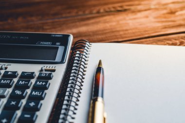 bir hesap makinesinin makro görüntüsü ve defter üzerindeki kalem