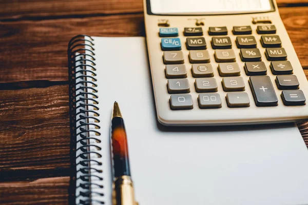 Hesap makinesi ve bir kalem ve defter. İş, finans, eğitim kavramı