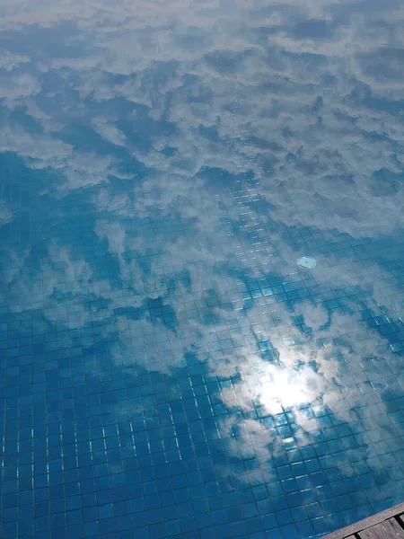 镜像反射的太阳 蓝天和云朵在游泳池里 瓷砖纹理 清澈的水 倒映在水面上 画面在水面上 抽象的背景 — 图库照片