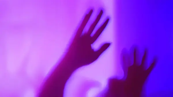 Defocused abstact silhouette of arm, hand spooky action, alien, ghost, Halloween concept, haunted and horror in multicolor background