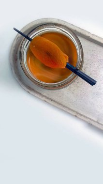 Üst manzara beyaz ahşap tepside ve arka planda bir kavanoz kirli kahve, üstünde kurumuş kayısı, kafe veya kahve menüsü, minimum konsept