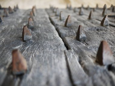 Eski bir ortaçağ ahşap kapısının yan görünüşü, paslı demirin seçici odağı, fotokopi alanı ile reklam için konsept görüntüsü.