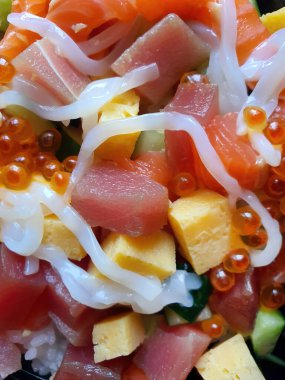 Chirashi Sushi Don, karışık deniz ürünleri kaplı pirinç, çiğ balık, Japon buharda pişmiş pirinç, somon balığı, Maguro ve Tamago, somon yumurtası, kalamar, kabak, yumurta.