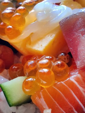 Chirashi Sushi Don, karışık deniz ürünleri kaplı pirinç, çiğ balık, Japon buharda pişmiş pirinç, somon balığı, Maguro ve Tamago, somon yumurtası, kalamar, kabak, yumurta.