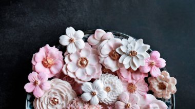 Sam Pan Nee, pastel pembe tonda Tayland tatlısı çeşitli çiçek şekilli Hindistan cevizi sütü tadı, otantik Tayland geleneksel el sanatları atıştırmalığı koyu arka planda