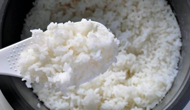 Beyaz kepçe üzerinde yumuşak Japon pilavı, lezzetli sıcak buhar pilavı, gıda endüstrisi, gıda sektörü, Asya tarzı sıcak yemek.