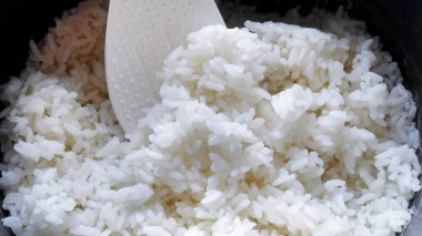 Beyaz kepçe üzerinde yumuşak Japon pilavı, lezzetli sıcak buhar pilavı, gıda endüstrisi, gıda sektörü, Asya tarzı sıcak yemek.