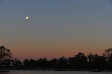 Gün batımında Mildura, Victoria, Avustralya 'daki Murray Nehri üzerinde ay ışığı parlıyor..