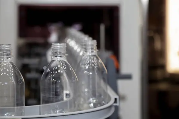 transparent plastic bottle on factory line machine in the beverage manufacturing, selective focus.