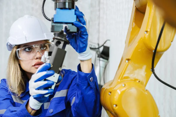 Üniversite ya da fabrika atölyesinde kadın otomasyon mühendisi öğrenci çalışması ve denetim kontrol robotu kol makinesi. ai robot teknolojisi endüstride yeni yenilik eğilimi 5.0