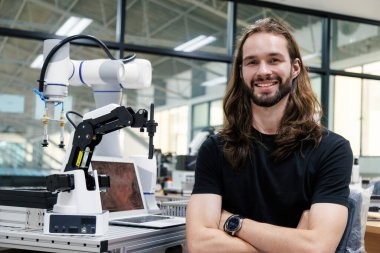 Üniversite atölyesinde erkek otomasyon mühendisi öğrenci çalışması ve teftiş kontrol robotu makinesi. ai robot teknolojisi endüstride yeni yenilik eğilimi 5.0