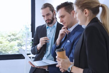 İş ekibi ana plan üzerinde çalışıyor. Mutlu gülümseyen işadamı ve iş kadını başarılı pazarlama planından bahsedip müdüre sunuyorlar..