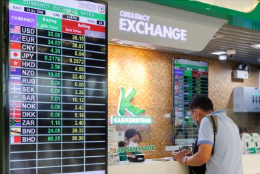 Bangkok, Tayland - 26 Kasım 2023 Suvarnabhumi Havaalanı 'ndaki bankada döviz kuru sergisi olan Asyalı iş adamı. Enflasyon ekonomik. Seçici odak.