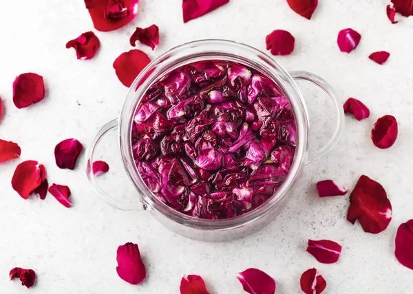 stock image Top view of a glass pot with pink organic rose petals for making sweet syrup, alcoholic beverage, liquor or flower flavor wine. Sweet food concept.