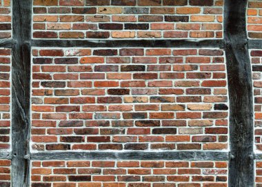 Ağartılmış ahşap kirişler ve kırmızı tuğla taşlarla yıpranmış ahşap çerçeve duvarı. Arkaplan veya doku.