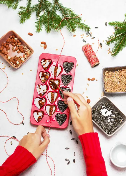 stock image Step 5. Threading the ribbon, string, or twine in each heart bars for hanging. Making birdseeds cookies. Help people to animals. Top view