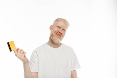 pleased and bearded albino man in t-shirt holding credit card on white background clipart