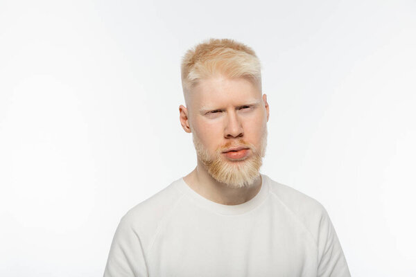 bearded and serious albino man in t-shirt looking at camera isolated on white 