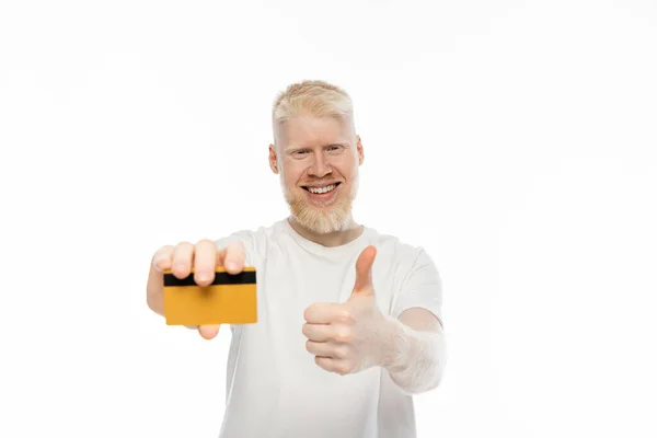 stock image happy albino man holding credit card and showing thumb up isolated on white 