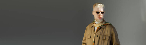 sunlight on face of stylish albino man in sunglasses and shirt jacket on grey, banner 