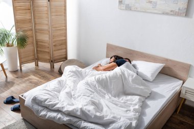 Man hugging girlfriend on bed in morning 