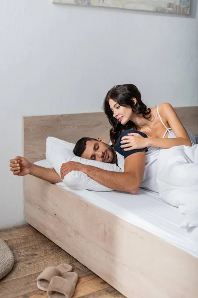 Smiling Woman Touching Sleeping Boyfriend Bed — 图库照片
