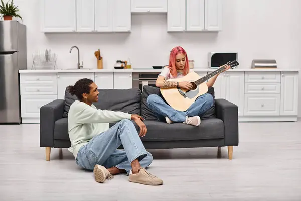 ジョリー アフリカ系アメリカ人 ホームウェア 彼のピンク髪のガールフレンド ギターを演奏 ロイヤリティフリーのストック画像