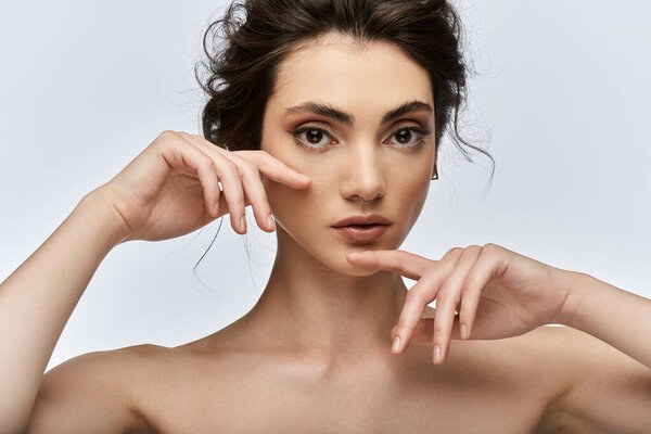 Крупный план молодой женщины с темными волосами и элегантной одеждой, руки в обрамлении лица.