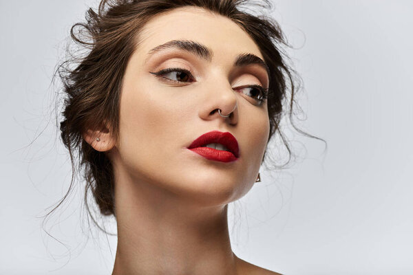 Портрет молодой женщины с темными волосами и красной помадой.